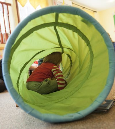 kid playing in toy tunnel