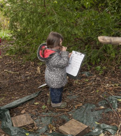 child standing with a clipboard