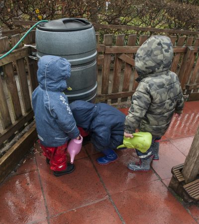 children getting water from water barrel